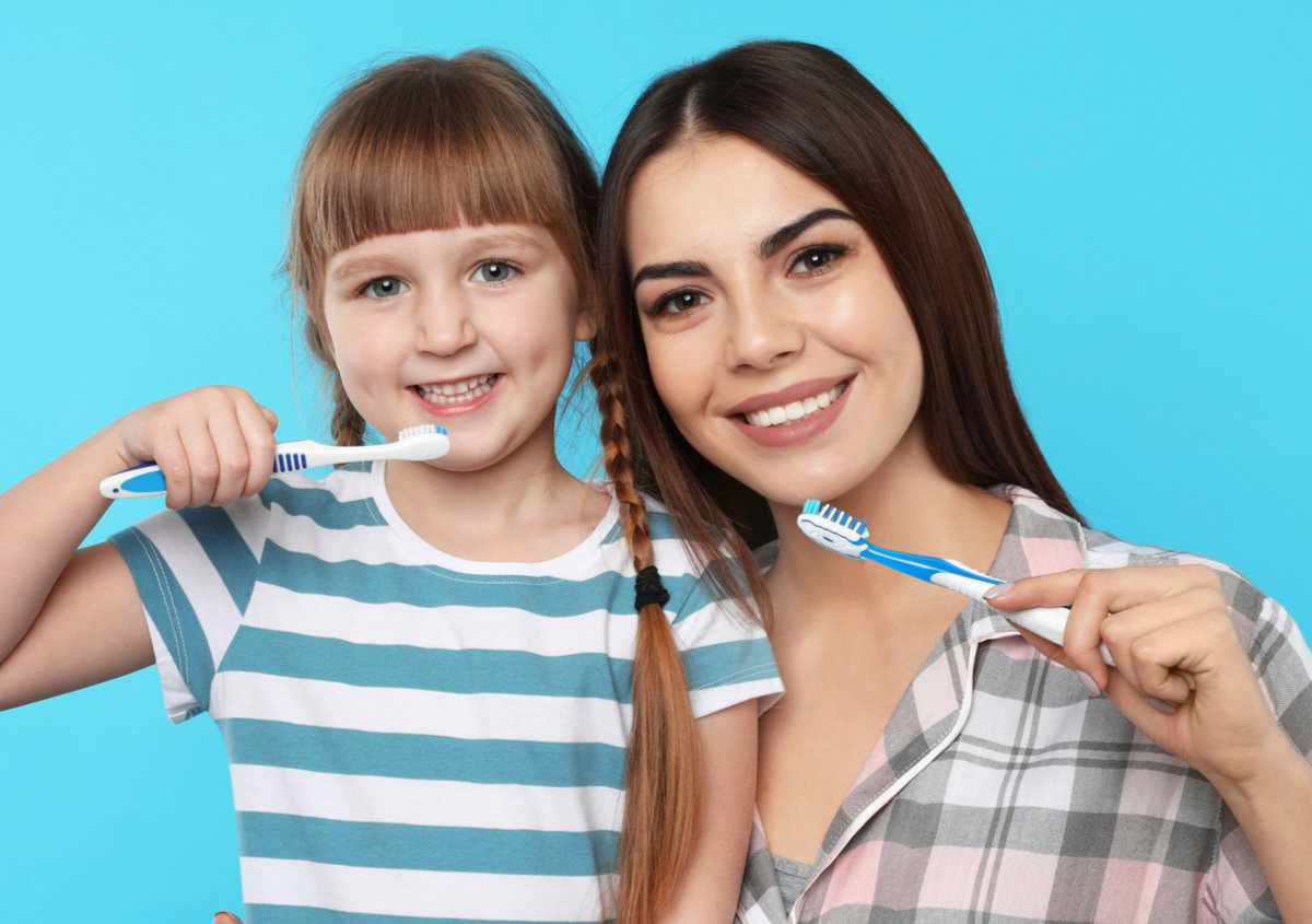 A mother and daughter brushing teeth.