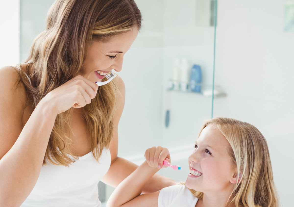 A mother and daughter brushing teeth.
