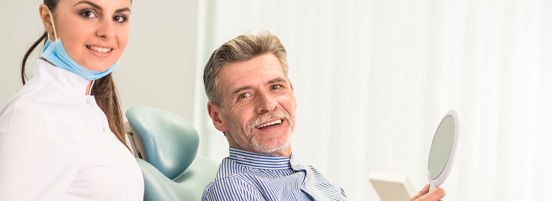 A happy patient is wearing dentures.