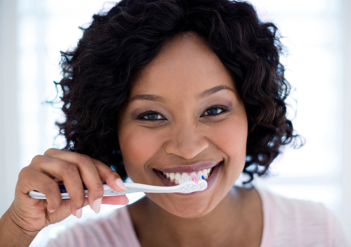 A woman is brushing her teeth.